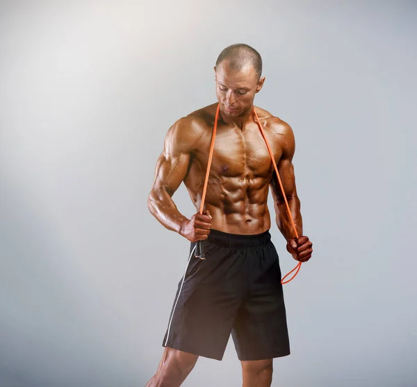 Fitness Hombres flexionando los músculos y posando con la cuerda de salto —  Fotos de Stock