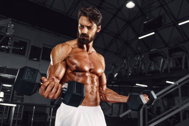 Spor salonunda vücut geliştirme egzersizi. Yakışıklı Vücut Geliştirici Spor Salonunda Ağırlık Kaldırıyor. Boşluğu Kopyala