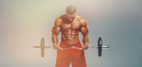 Kulturista dělá Barbell Bicep Curls. Studio Shot. Kopírovat mezeru — Stock fotografie