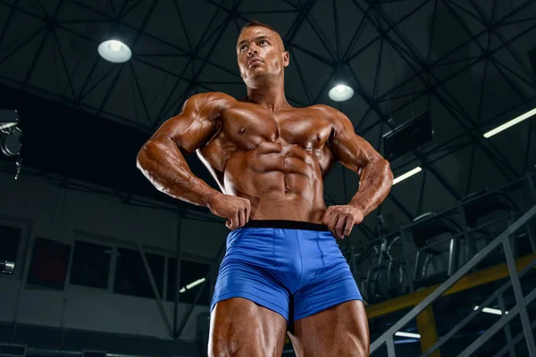 Starka, muskulösa, stiliga män som spänner musklerna i gymmet. Bodybuilder Flexing Muscles i gymmet. Kopiera utrymme — Stockfoto