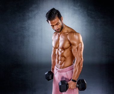 Güçlü kaslı adamlar ağırlık egzersizi yapar. Vücut geliştirici halterli biseps yapıyor.