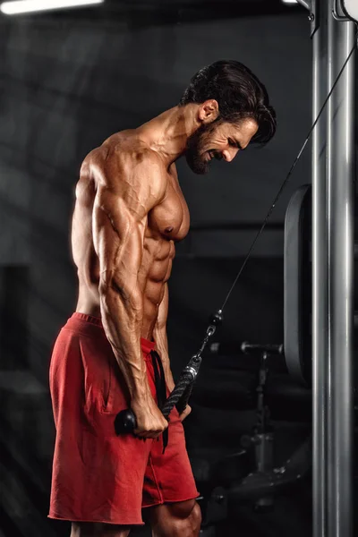 Trening kulturystyki w siłowni. Bodybuilder Lifting Weights in the Gym, wykonując trening tricepsów kablowych. Przestrzeń kopiowania — Zdjęcie stockowe