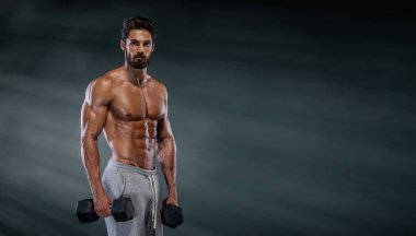 Yakışıklı kaslı adamlar, Dambıllarla Vücut Geliştirme Eğitimi. Boşluğu Kopyala