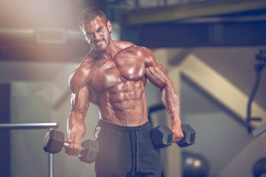 Spor salonunda vücut geliştirme egzersizi. Spor salonunda vücut geliştirici ağırlık kaldırıyor.