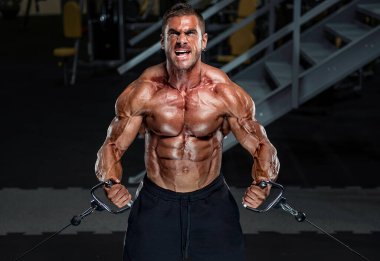 Spor salonunda vücut geliştirici egzersizi. Göğüs kasları için Çapraz Egzersiz Yapılıyor