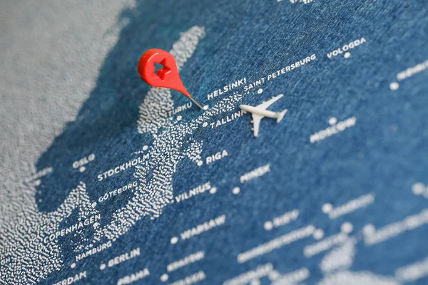 painted travel map with the pin and plane