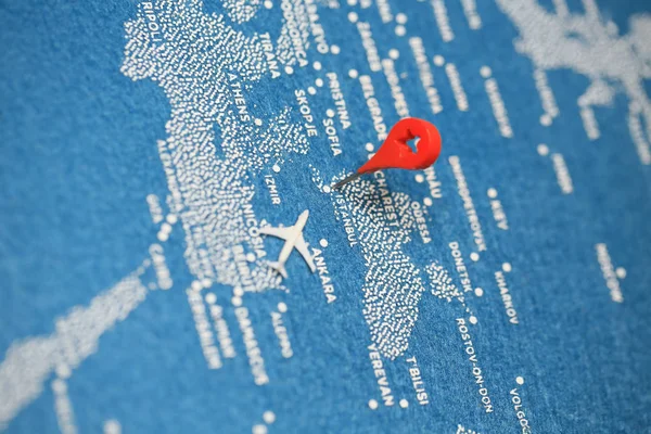 painted travel map with the pin and plane