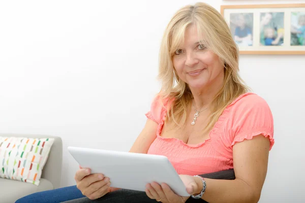 Gyönyörű érett nő használ elektronikus tabletta otthon — Stock Fotó