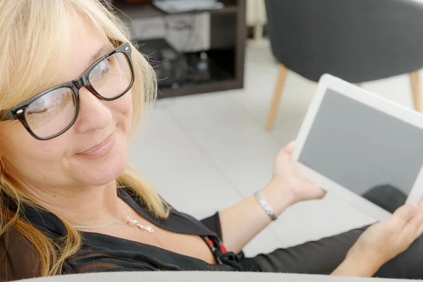 Hermosa mujer madura usando tableta electrónica en casa —  Fotos de Stock