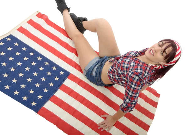 Mooie jonge vrouw liggend op een Amerikaanse vlag — Stockfoto