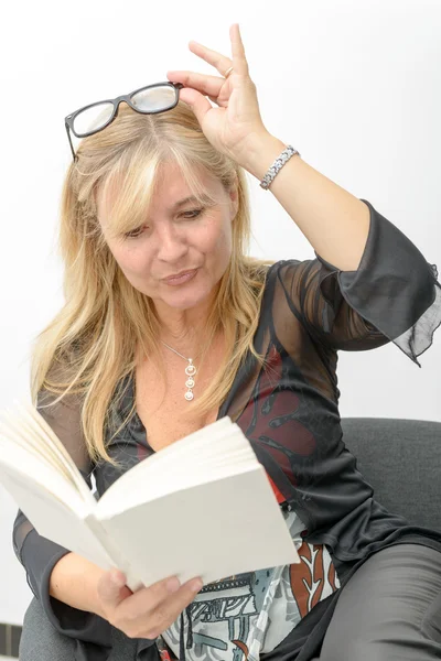 Mature blond woman reading a book — Stock Photo, Image
