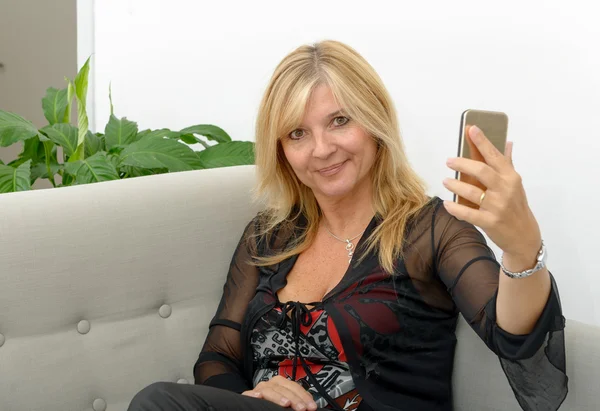 Smiling mature woman using smartphone Stock Image