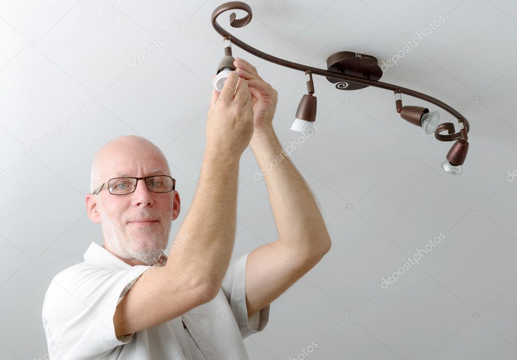 Man replacing the light bulb at home