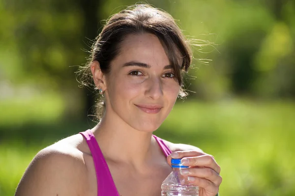 Chica atlética beber agua después de hacer ejercicio —  Fotos de Stock