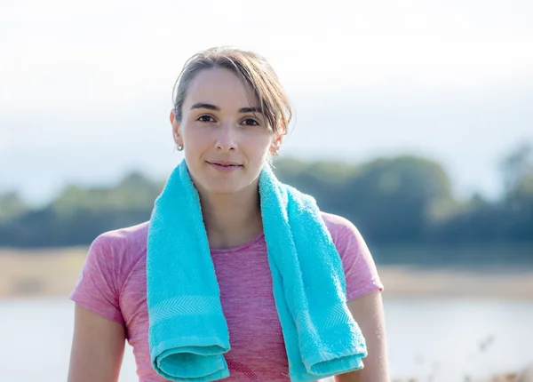 Mladá žena sportovní s modrým ručníkem na venkově — Stock fotografie