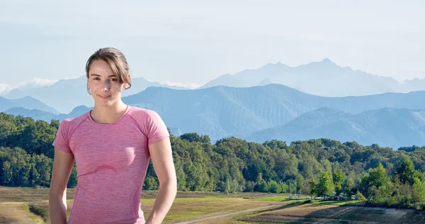 Portret van jonge sportieve vrouw, bergen achtergrond — Stockfoto