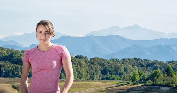 Portrait de jeune femme sportive, fond de montagne — Photo