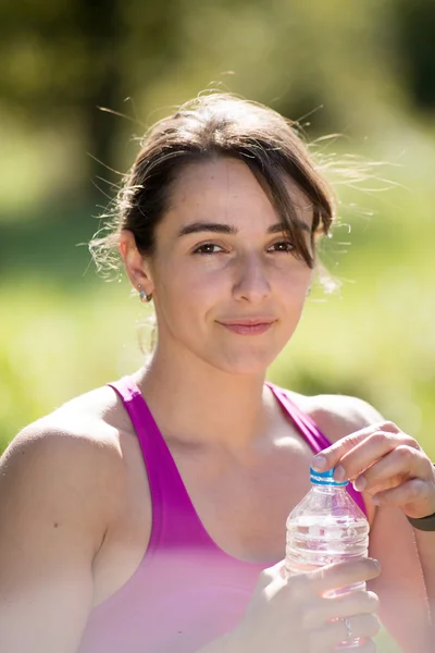 Спортивна дівчина п'є воду після фізичних вправ — стокове фото