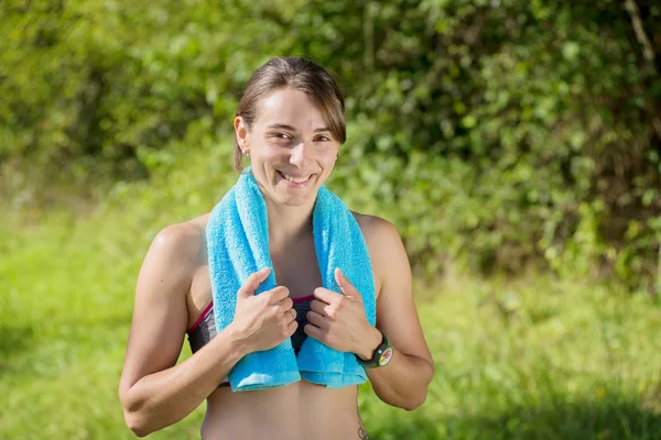 Junge sportliche Frau mit blauem Handtuch auf dem Land — Stockfoto