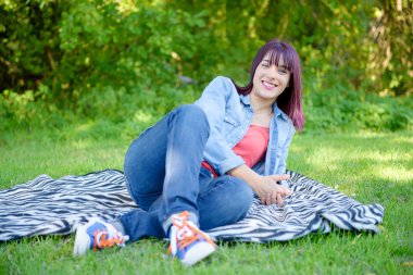 güzel ve genç birbayan Jeans çim üzerinde yalan