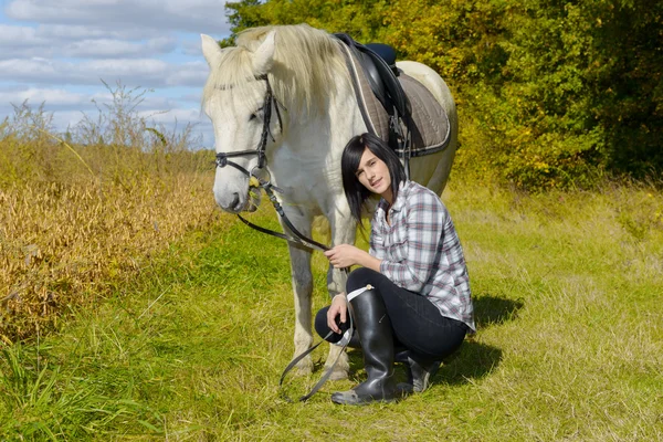 Молода дівчина вершника зі своїм білим конем — стокове фото