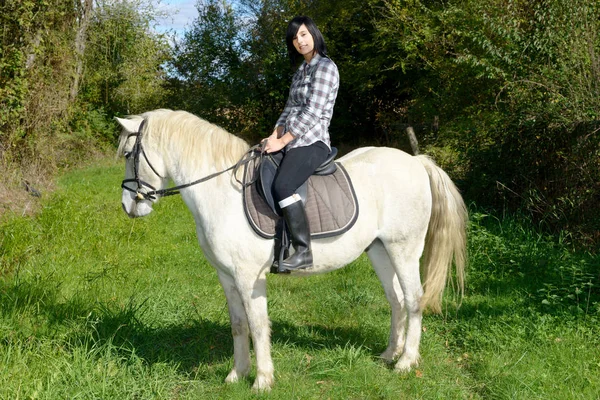 Jeune belle femme brune à cheval — Photo