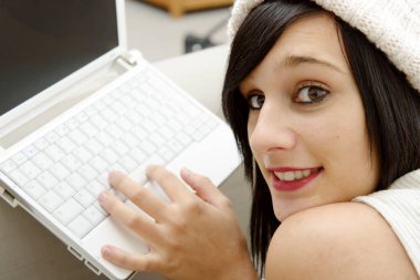 bir dizüstü bilgisayar ile kanepede yatan genç esmer öğrenci