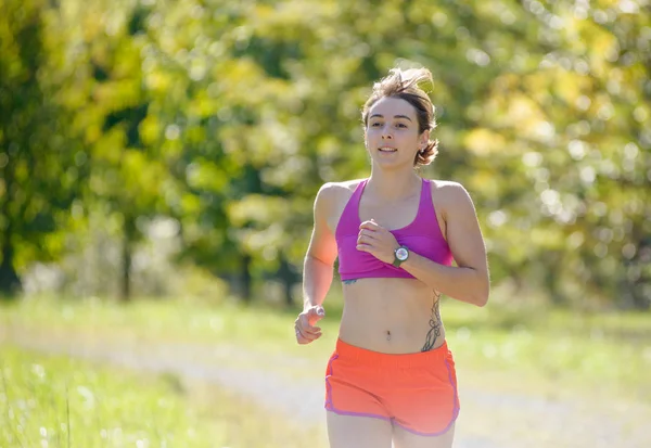 Beautiful athletic woman running in countryside — Stock Photo, Image