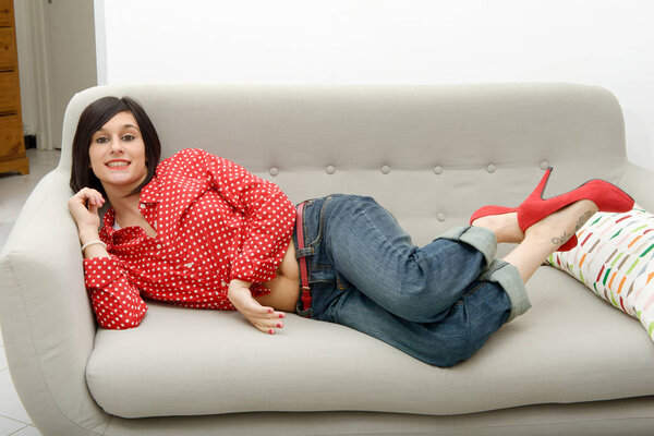 young woman with jeans lying in the sofa