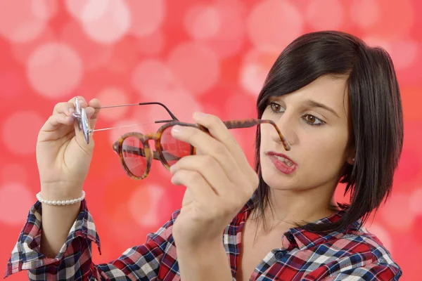 Junge Frau vergleicht Brille — Stockfoto