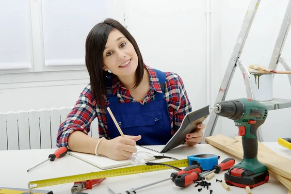 Woman carpenter sitting at desk in her workshop — Stock Photo, Image