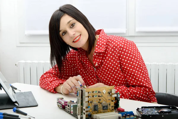 Brünette frau techniker repariert einen computer — Stockfoto