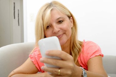 Smartphone kullanarak gülümseyen Olgun kadın