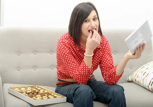 Mladá brunetka eats čokoláda — Stock fotografie