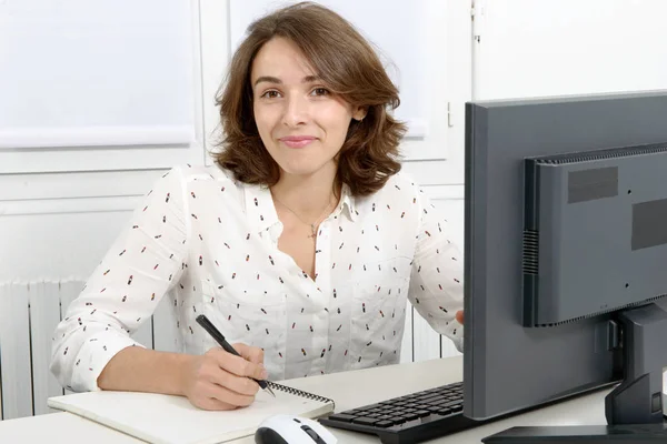 Hübsche junge Geschäftsfrau arbeitet am PC im Büro — Stockfoto