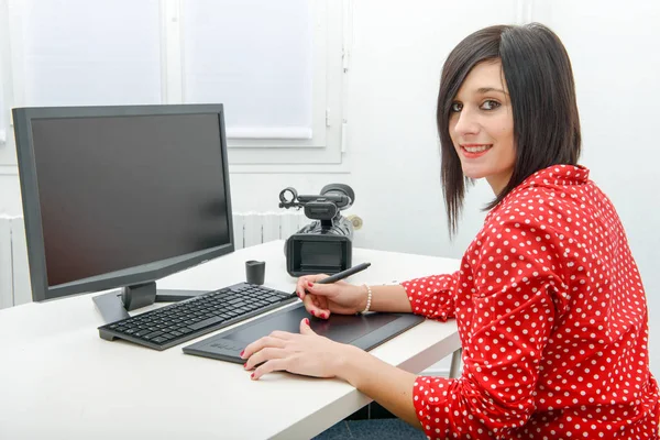 Joven diseñadora femenina usando tableta gráfica mientras trabaja con c — Foto de Stock