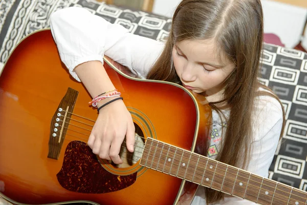 Mladá dospívající dívka hraje na akustickou kytaru — Stock fotografie