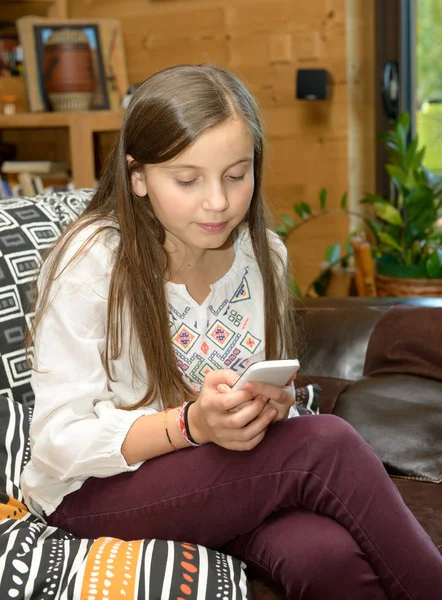 Young teenager on the sofa sends a text message — Stock Photo, Image