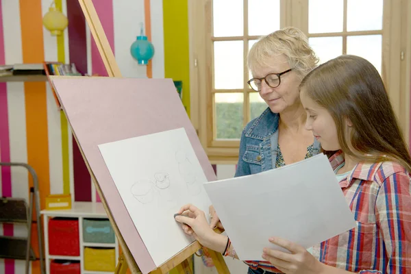 Девушка-подросток рисует со своим учителем — стоковое фото