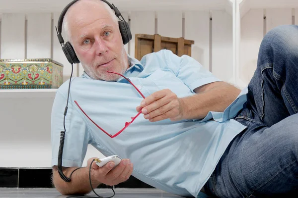 Handsome mature man listening to music with headphones — Stock Photo, Image