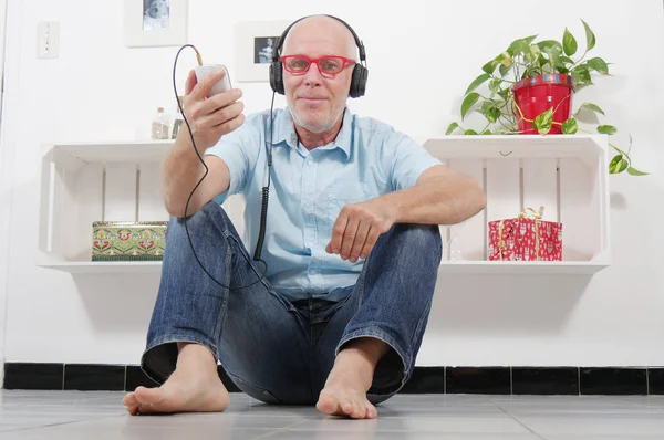 Szép érett férfi zenehallgatás fejhallgató — Stock Fotó