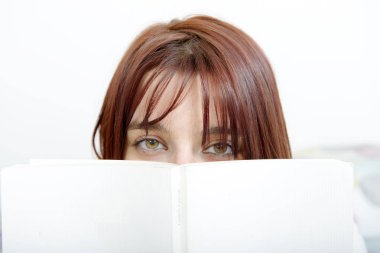 güzel kız bir kitap onun yatağında okur.