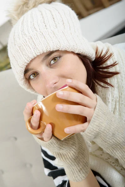 Genç bayan bir fincan çay içiyor.