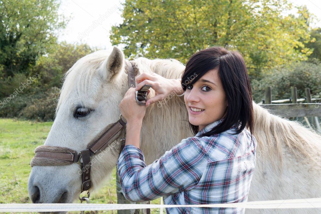 Beautiful young woman and white horse