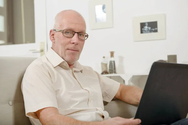 Mature man using laptop at home — Stock Photo, Image