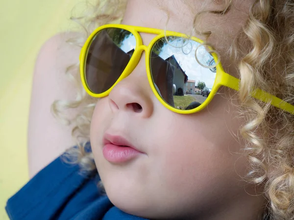 Pequeño niño rubio con gafas de sol amarillas — Foto de Stock