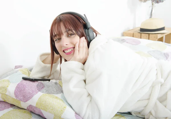 Schönes junges Mädchen hört Musik in ihrem Bett — Stockfoto