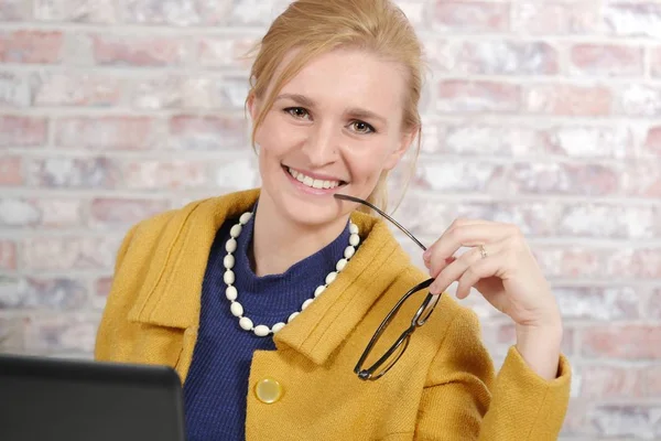 Mooie jonge zakenvrouw met een gele jas — Stockfoto