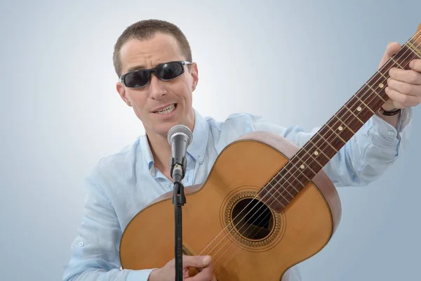 Homme avec une guitare acoustique dans ses mains — Photo