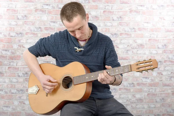 Homme avec une guitare acoustique dans ses mains — Photo